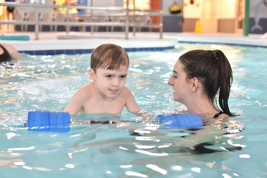 Swim lesson in natatorium pool with young boy