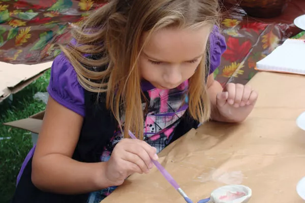 Little girl paints pottery
