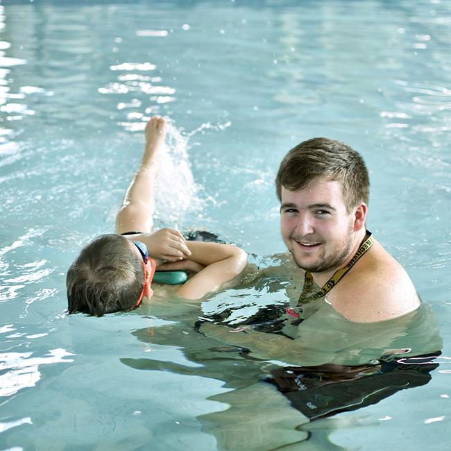 Swimmer works on backstroke with instructor